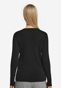 Svart långärmad tröja med en texturerad, glittrig finish. Har en rund halsringning och en figurnära silhuett, synlig från baksidan.