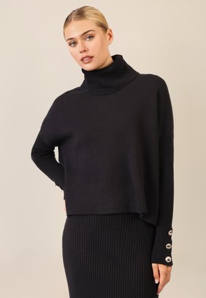 Schwarzer Rollkragenpullover mit geripptem Design, langärmlig und mit Knopfdetails an den Bündchen. Weiche Textur und lockere Passform.
