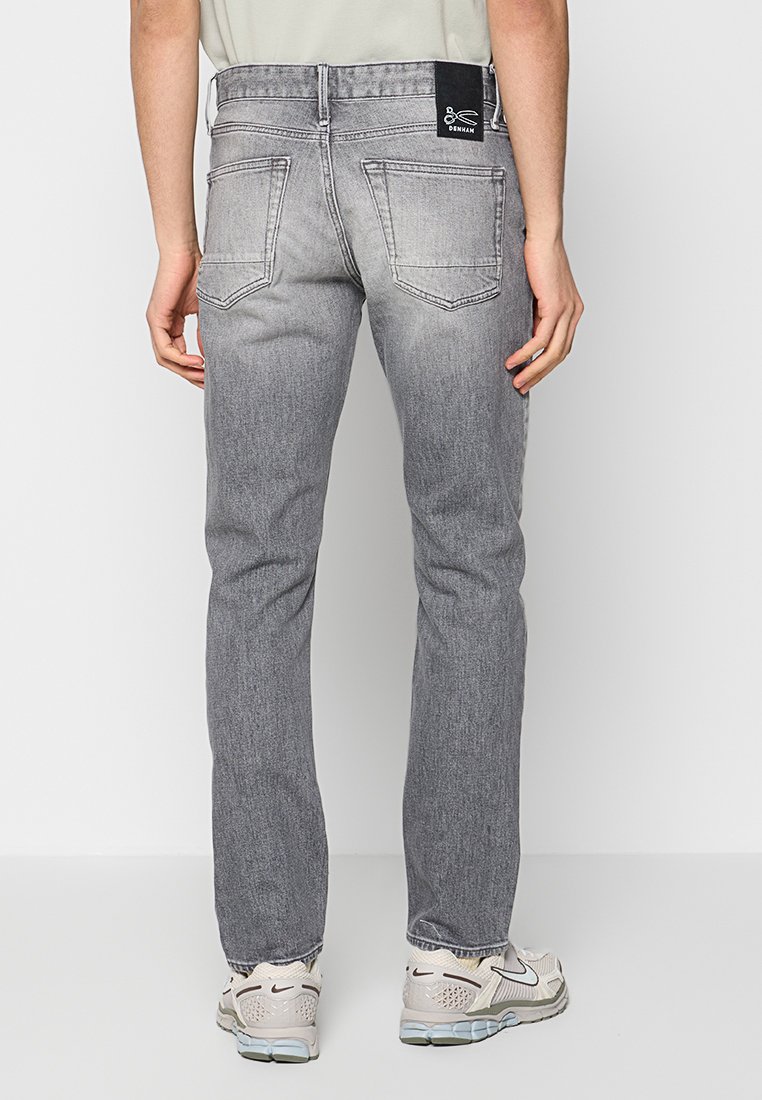 Slim-fit, grijze denim jeans met een vervaagde afwerking, vijf zakken en een zwart merklabel op de tailleband. Eenvoudig ontwerp aan de achterkant.