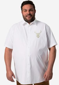 Camicia bianca a maniche corte con colletto classico, caratterizzata da un ricamo di un cervo verde chiaro sul lato sinistro del petto.
