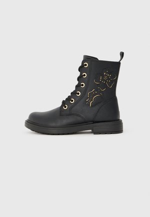 Schwarze Knöchelstiefel aus glattem Leder, mit goldenen Ösen, einem strukturierten floralen Design an der Seite und einer Profilsohle für besseren Halt.