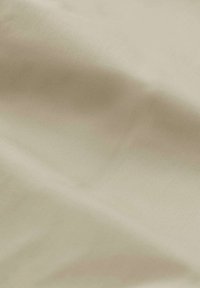 Tessuto beige morbido con una leggera lucentezza, che presenta una sottile trama e pieghe, ideale per applicazioni di abbigliamento o tappezzeria.