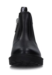 Stivale alla caviglia in pelle nera con zip laterale, punta tonda, suola spessa e linguetta in tessuto con testo bianco sul retro.