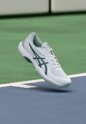 White and mint green athletic shoe with a textured upper, cushioned collar, and a white outsole, featuring a green accent logo design.