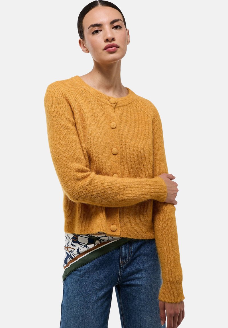 Cardigan en tricot jaune avec un col rond, fermeture à boutons et manches longues. Texture douce et matériau léger.