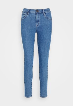 Jeans din denim albastru, fit skinny, cu cinci buzunare, decolorare ușoară și fermoar. Prezintă bucle pentru curea și un tiv cusut.