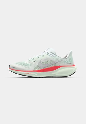 Baskets de course Nike vert clair avec une tige en mesh, présentant une semelle rose et blanche, affichant un design moderne et élégant.
