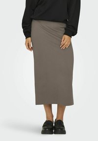 Jupe midi en coton gris avec une texture lisse et une taille élastique, associée à des chaussures à plateformes noires, créant un look décontracté.