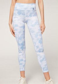 Ljusblåa leggings med ett molnmönster, hög midja och slät textur. Har kontrasterande sömmar och en liten logotypetikett framtill.