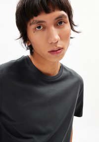 Black cotton crew neck t-shirt, short sleeves, smooth texture, close-fitting design, set against a white background.