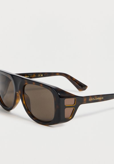 Ορθογώνια γυαλιά ηλίου σε σχέδιο καφέ χελώνας με σκούρους φακούς, χρυσές λεπτομέρειες κοντά στις μεντεσέδες και το λογότυπο "Dolce & Gabbana" στους βραχίονες.