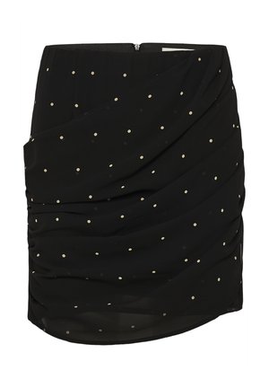 Mini-jupe noire à petits pois blancs avec des couches de tissu drapées et froncées, dotée d'une fermeture éclair au dos.