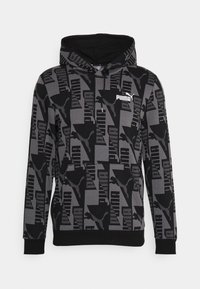 Sweat à capuche noir et gris avec un motif géométrique, poche kangourou et capuche. Logo affiché en blanc. Matière douce avec poignets élastiques.