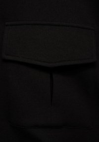 Material negru cu o buzunare mare, dreptunghiulară, în centrul său. Textură netedă, fără modele vizibile sau detalii de hardware.