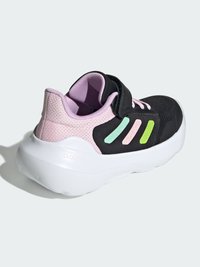 Chaussure de sport noire avec empeigne en mesh, accents roses, semelle blanche et sangle ajustable, avec des rayures vertes et roses sur le côté.