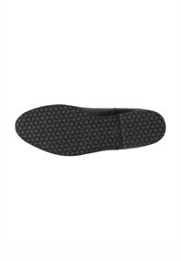 Semelle de chaussure noire avec un motif hexagonal conçu pour l’adhérence, montrant une usure uniforme et un bord lisse.