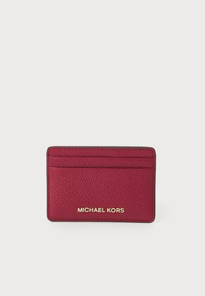 Porta carte in pelle rossa a trama di perle con più slot, caratterizzato dal logo dorato "MICHAEL KORS". Forma rettangolare con bordi cuciti.
