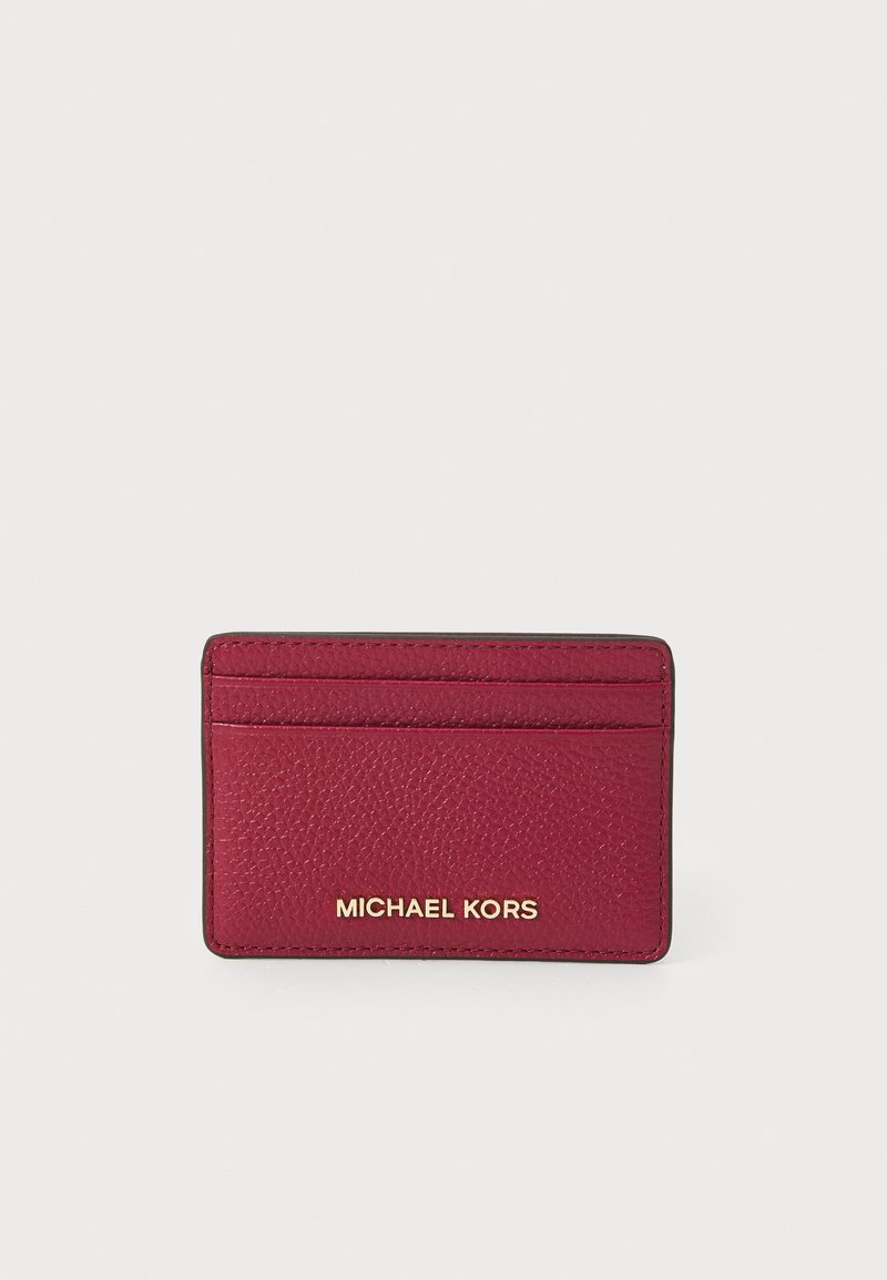 Rød pebret skinn kortholder med flere lommer, med gull "MICHAEL KORS"-logo. Rektangulær form med sydd kanter.
