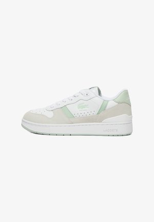 Baskets Lacoste arborant un schéma de couleurs blanc et vert clair, avec des matériaux en daim et en cuir, des détails perforés et une épaisse semelle blanche.