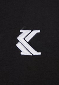Čierna tkanina s výrazným bielym vyšitým logom, ktoré obsahuje tri zakrivené línie, čím pridáva textúru a kontrast.