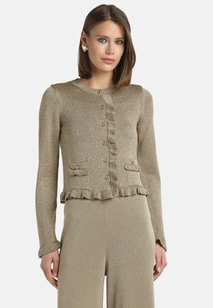 Gold metallic cardigan with ruffle detail, round neckline, long sleeves, and button closure. Features two front pockets with gold accents.