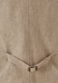 Beige Leinenbekleidung mit strukturiertem Finish, ausgestattet mit einem Schlaufen- und Gurtverschluss, glatten Kanten und einem klaren, schlichten Design.