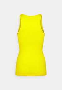 Żółta bezrękawnikowa koszulka o dopasowanym kroju, wykonana z gładkiego, elastycznego materiału. Brak wzorów lub ozdobników; jednolity kolor w całym fasonie.