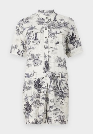 Short-sleeve, collared romper in cream with navy tropical print. Features buttons, two chest pockets, and a tie belt at the waist.