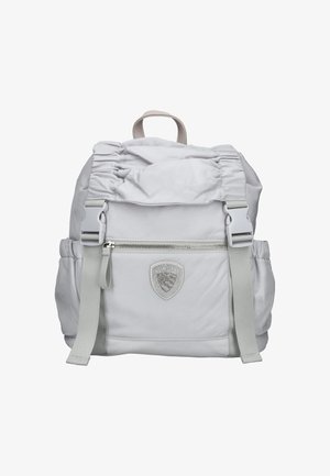 Světlá šedá batoh s mašlí na vrchu, přední kapsou na zip, nastavitelnými popruhy a texturovanou nášivkou loga na přední straně. Hladký povrch látky.