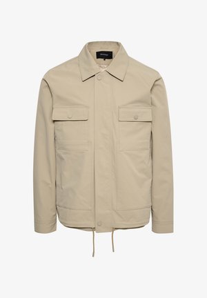 Beżowa kurtka wykonana z miękkiego materiału, z zapięciem na guziki, dwoma kieszeniami na piersi i regulowanym ściągaczem u dołu. Klasyczny krój kołnierza.