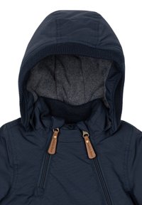 Veste à capuche bleu foncé avec une doublure intérieure douce grise, bordure côtelée autour de la capuche et deux fermetures éclair verticales à l'avant avec des tirettes en cuir marron.