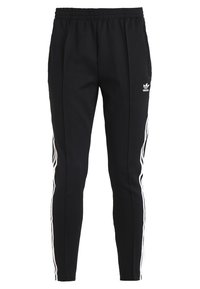 Black Adidas track pants with white three-stripe side panels and elastic waistband, featuring the Adidas Trefoil logo on the right thigh.