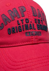 Rote Mütze mit dunkelblauer gestickter Aufschrift "CAMP DAVID ORIGINAL BRAND", ausgestattet mit einem gebogenen Schirm und strukturiertem Stoffdetail.