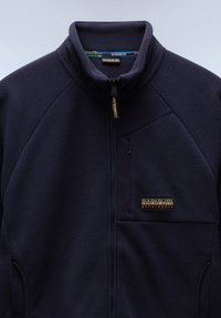 Fleecejacke in dunkelblau mit hohem Kragen, durchgehendem Reißverschluss und einer linken Brusttasche. Verfügt über einen Markenlogo-Patch und eine glatte Textur.