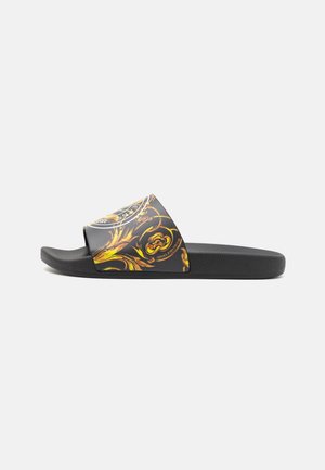 Schwarze Slide-Sandale mit breitem Riemen mit goldenen barocken Blumenmustern und weißem rundem Logo.