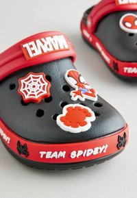 Crocs negri cu o brățară roșie, prezentând personaje Spider-Man, pânze de păianjen și textul "ECHIPA SPIDEY!". Suprafață texturată, accente decorative.
