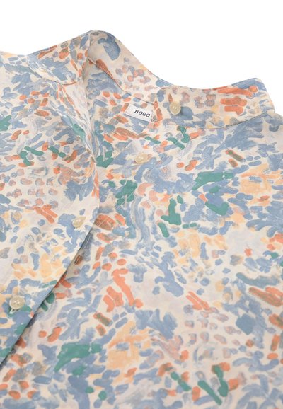Col de chemise avec patte de boutonnage devant, tissu à motif abstrait multicolore aux tons bleu, vert, orange et beige, étiqueté "BOBO."