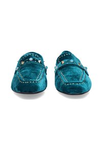 Zapatillas de terciopelo turquesa con acentos de tachuelas. Presentan un diseño de punta afilada y costuras decorativas a lo largo de los bordes. Suela plana.