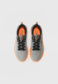 Gray athletic shoes with black laces and a textured upper. Bright orange accents on the insole and sole. Lightweight design, pull tab at heel.