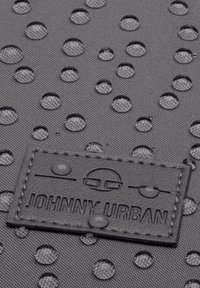 Szürke textil kiemelkedő pöttyös mintával és vízcseppekkel; tartalmaz egy fekete bőrcímkét, amelyen a "JOHNNY URBAN" felirat szerepel, dombornyomott logóval.