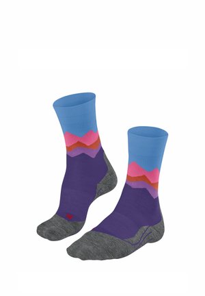 Bunte Socken mit blauem Bund, lila Körper und einem Bergmuster in Pink- und Orangetönen. Hergestellt aus strukturiertem Stoff, graue Sohlen.