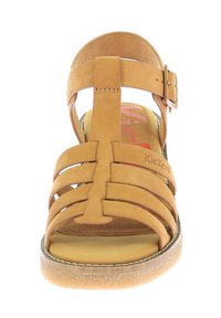 Sandalía plana de tiras en tono marrón, hecha de cuero, con una correa de hebilla y una plantilla texturizada que incluye el nombre de la marca.