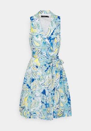 Mouwloze wikkeljurk met kraag, tailleband en blauw, geel en groen paisleymotief op een witte achtergrond.