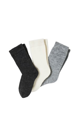 Trois paires de chaussettes en laine en gris foncé, blanc et gris clair, disposées côte à côte sur un fond blanc.