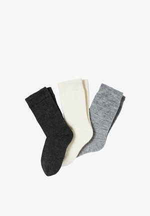 Trois paires de chaussettes en laine en gris foncé, blanc et gris clair, disposées côte à côte sur un fond blanc.