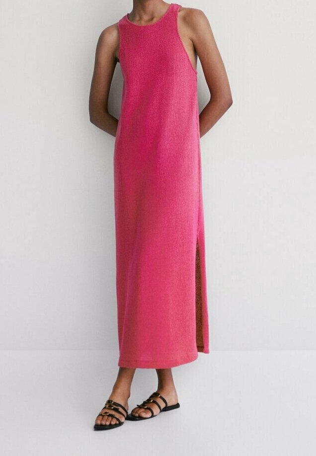 Robe longue sans manches aux nuances dégradées de rose, avec une texture côtelée et une fente latérale. Portée avec des sandales noires à lanières.