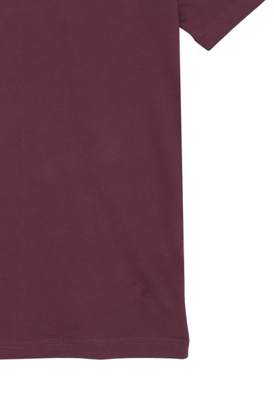 T-shirt in cotone bordeaux con maniche corte, bordo dritto e texture morbida, con una piccola macchia vicino all'orlo.