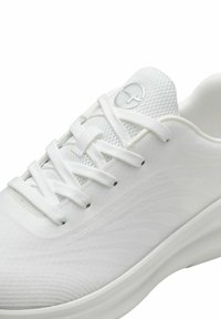 White athletic shoe with a mesh upper, smooth fabric, and textured sole. Features white laces and a logo on the tongue.