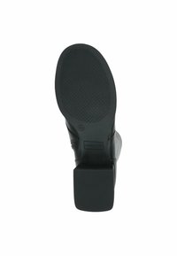 Bota negra con un empeine de cuero suave y una suela de goma texturizada con un tacón cuadrado. Marcada con el logo "Caprice" cerca de la base.