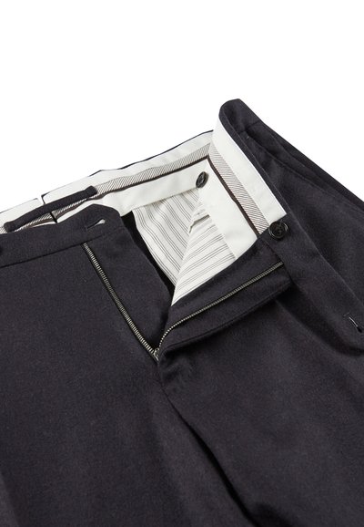 Granatowe spodnie z zamkiem błyskawicznym, dwoma guzikami i pasek w paski wewnątrz. Materiał wydaje się miękki o gładkiej teksturze.